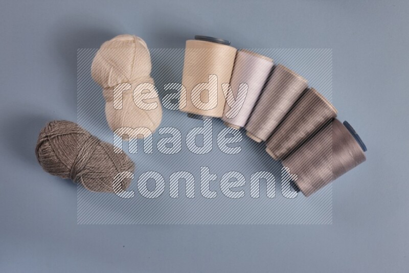 مجموعة من أدوات الخياطة والتفصيل رمادية اللون على خلفية زرقاء