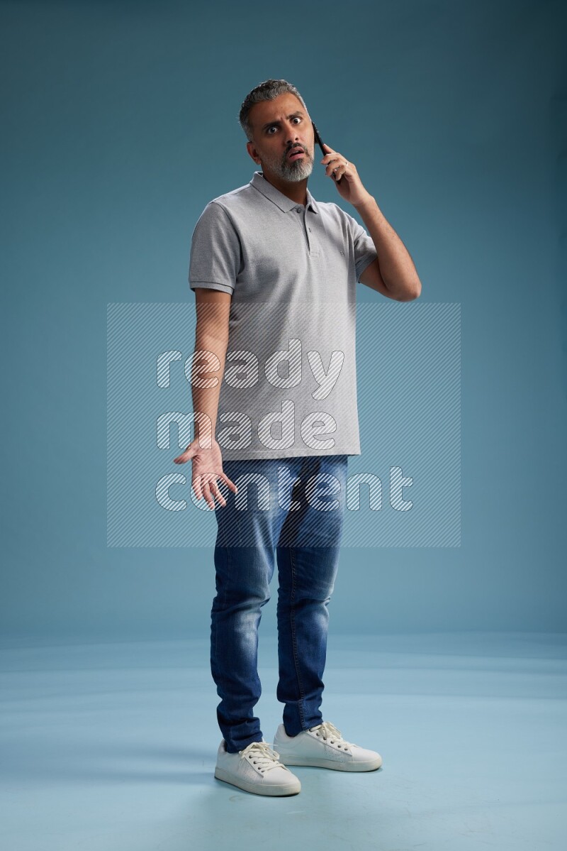 Man Standing talking on phone on blue background