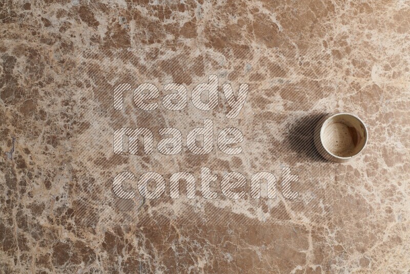 A multicolored pottery bowl on beige marble background