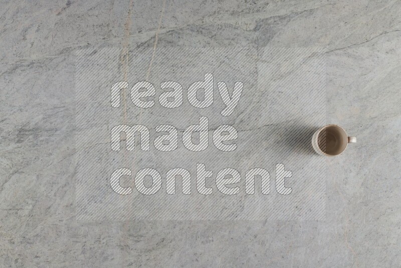 A multicolored pottery Cup on grey marble background