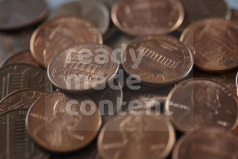 A close-up of scattered United States one cent coins on grey background