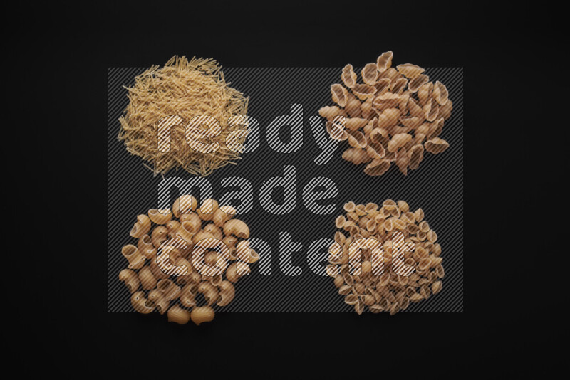 Different pasta types in bunches on black background
