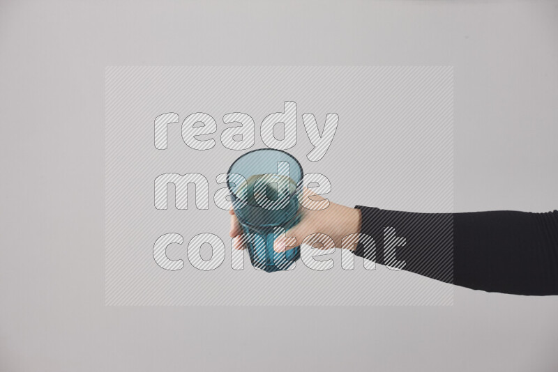 A woman in black abaya holding different glassware in different positions