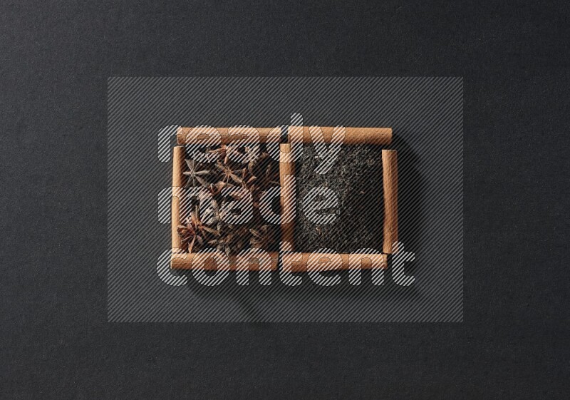 2 squares of cinnamon sticks full of star anise and black tea on black flooring