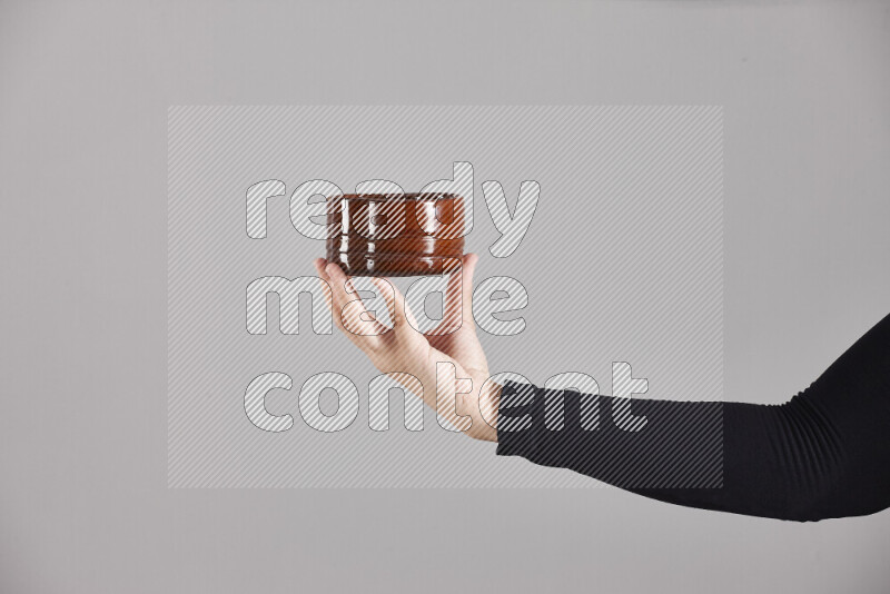 A woman in black abaya holding different pottery essentials in different positions