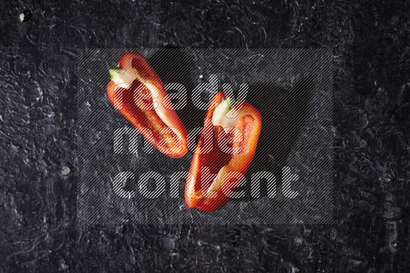 Red bell pepper slices on black background