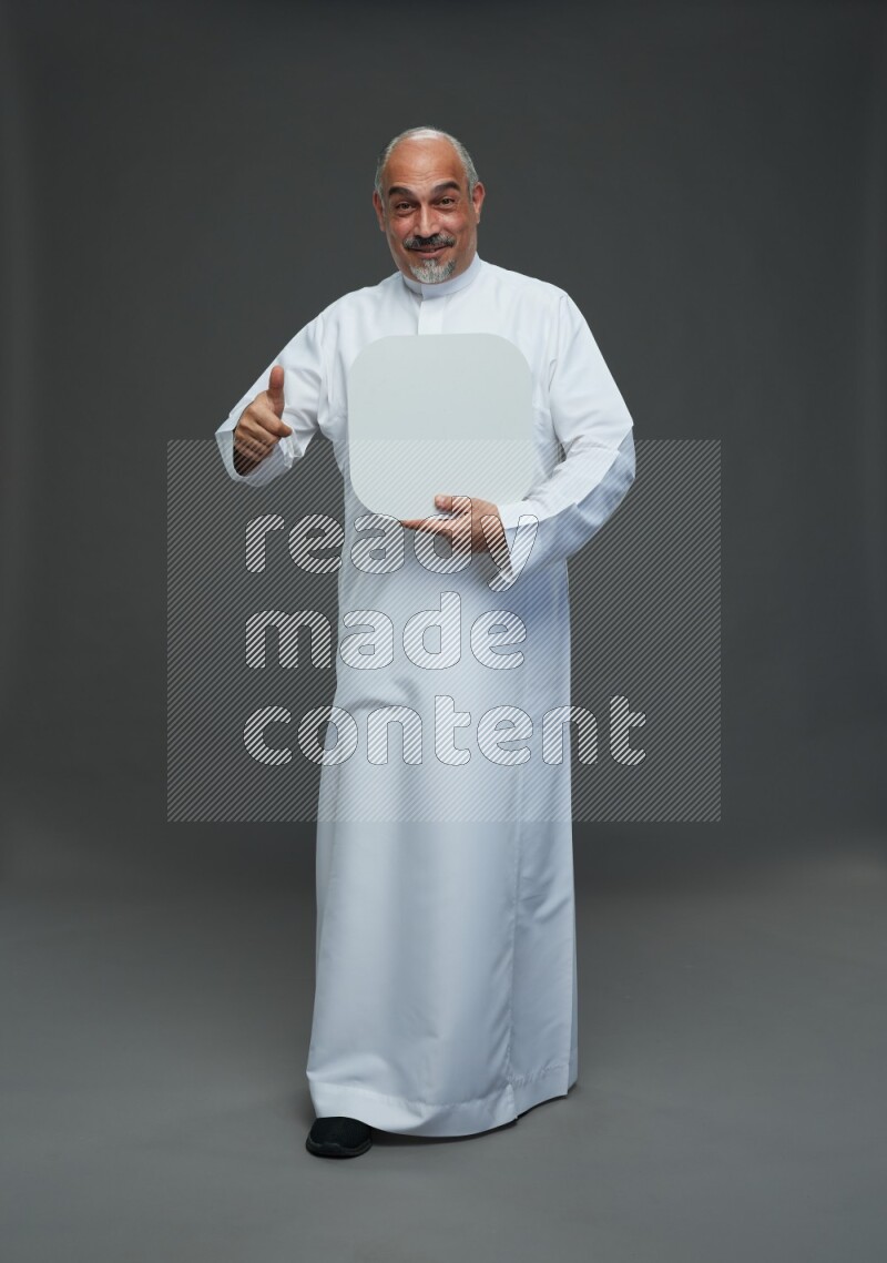 Saudi man without shomag Standing holding social media sing on gray background
