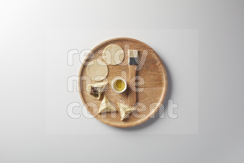 two closed sambosas and one open sambosa filled with meat while oil with oil brush aside in a wooden dish on a white background