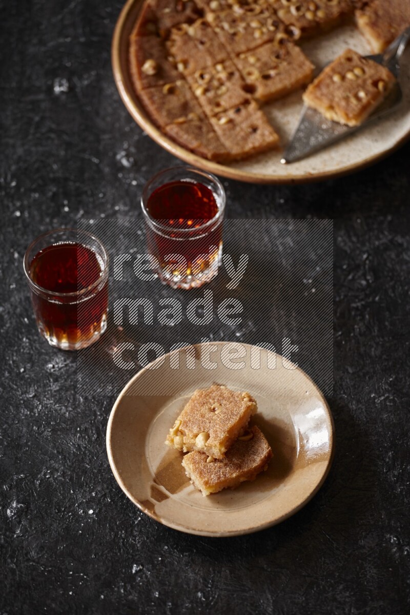 Basbousa with tea in a dark setup