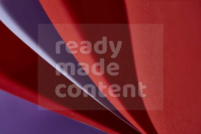 An abstract art showing purple and red paper sheets arranged in an overlapping curves