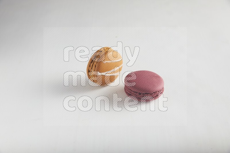 45º Shot of of two assorted Brown Irish Cream, and Red Cherry macarons on white background