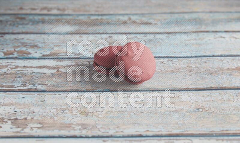 45º Shot of two Red Cherry macarons on light blue wooden background