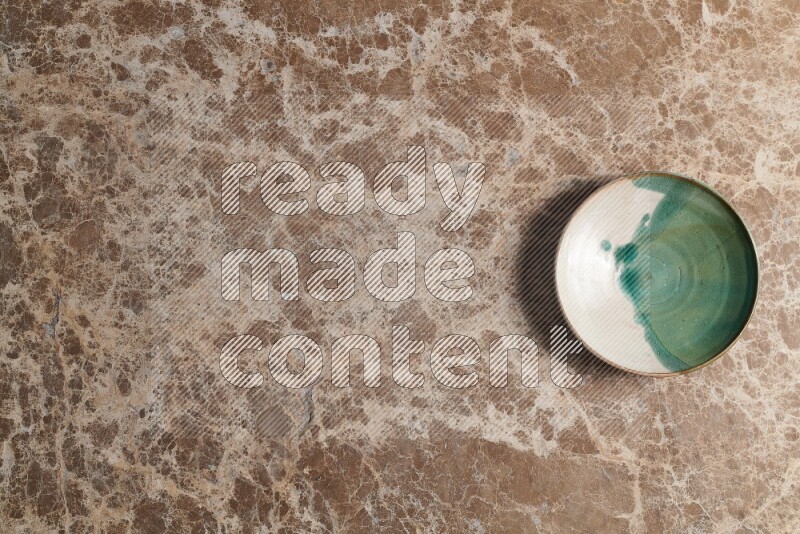 A decorative pottery plate on beige marble background