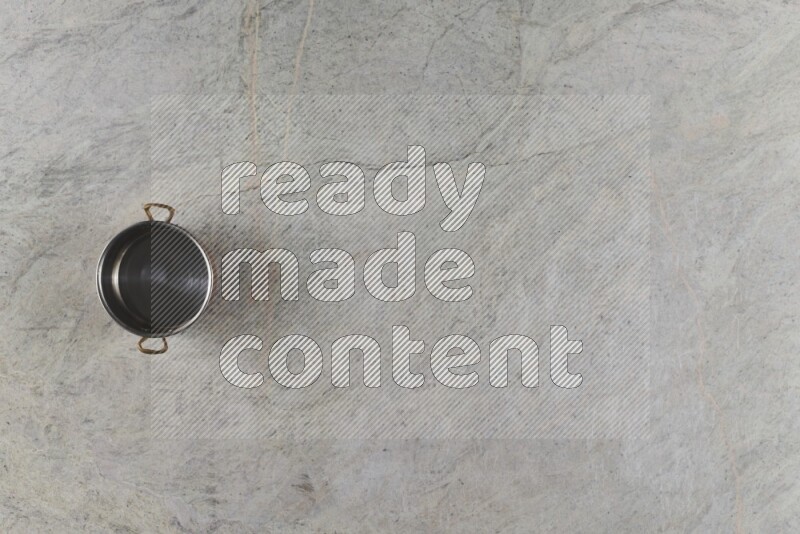 A small copper pot on grey marble background