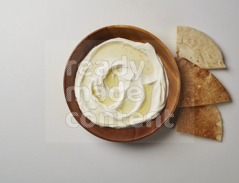 Lebnah garnished with olive oil in a wooden plate on a white background
