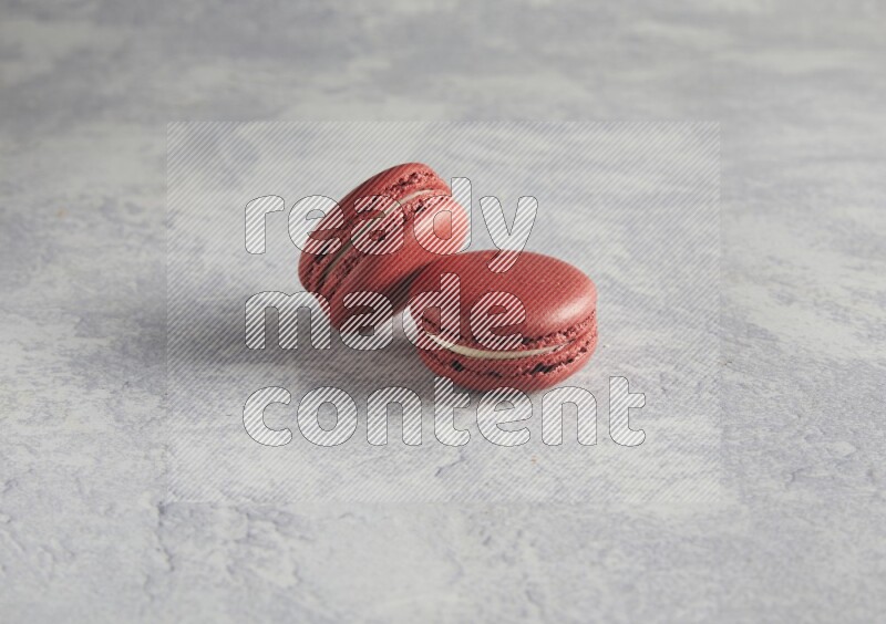 45º Shot of two Red Velvet macarons  on white  marble background