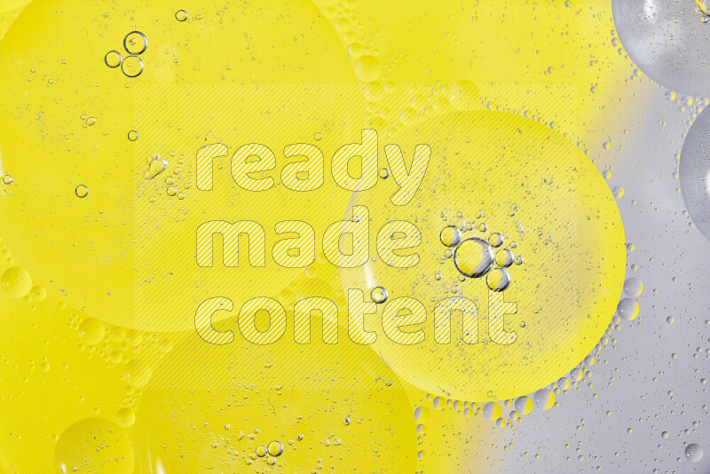 Close-ups of abstract oil bubbles on water surface in shades of white and yellow