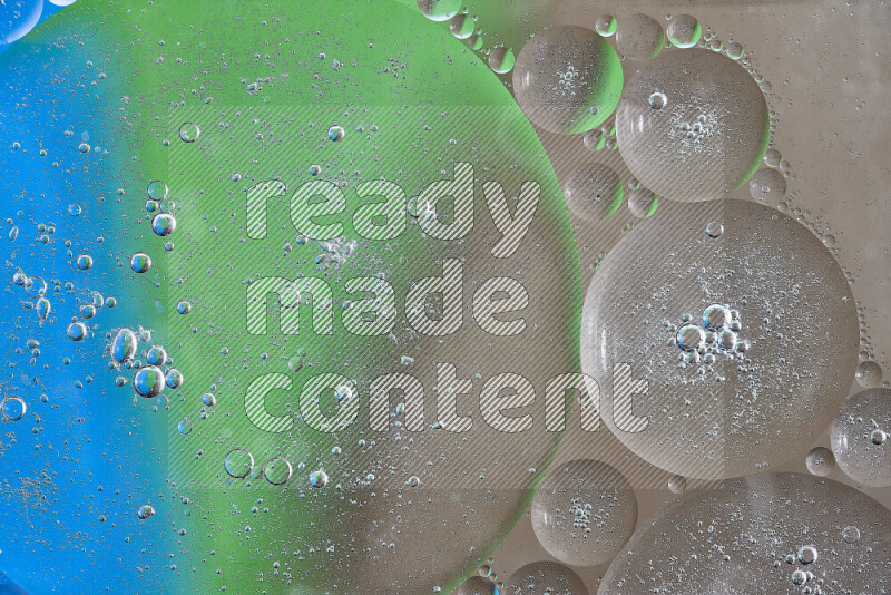Close-ups of abstract oil bubbles on water surface in shades of brown, green and blue