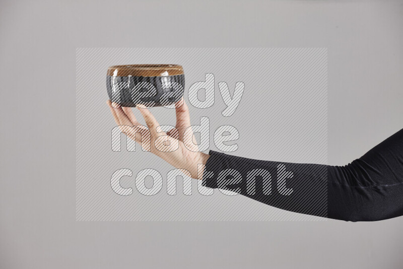 A woman in black abaya holding different pottery essentials in different positions