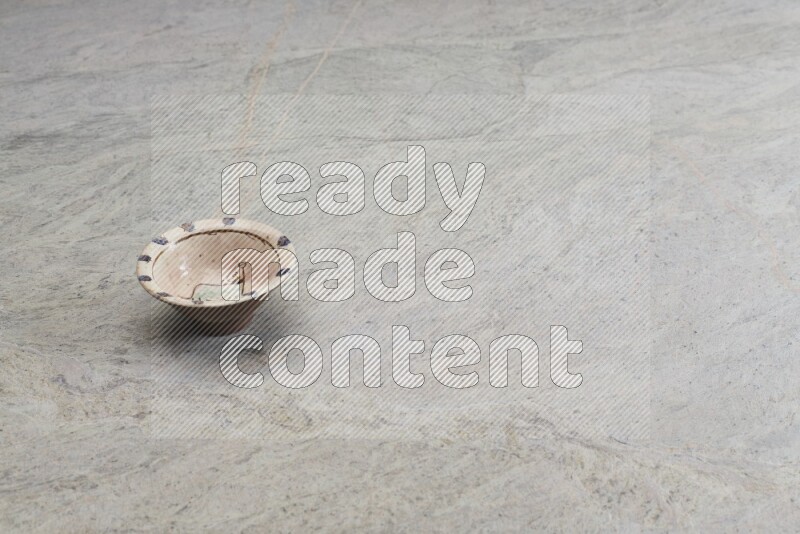 A decorative pottery plate on grey marble background