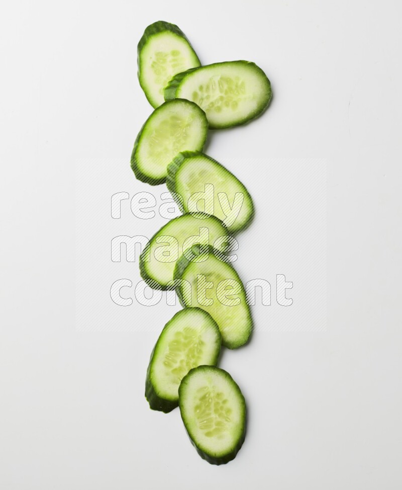 Multiple cucumber slices on white background