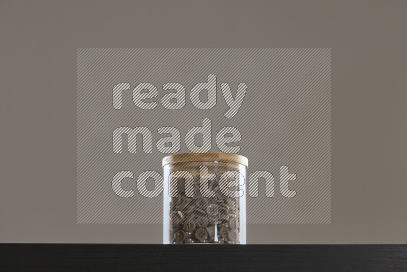 أزرار متنوعة في وعاء زجاجي علي خلفية سوداء