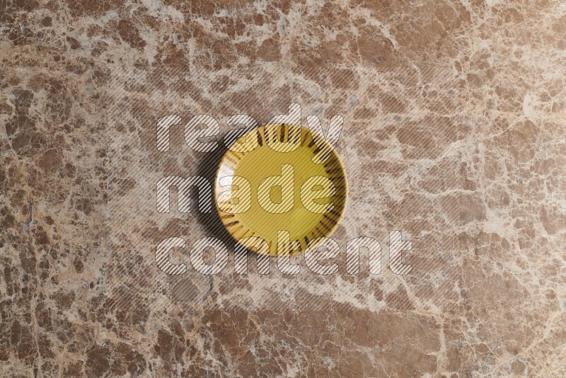 A multicolored pottery plate on beige marble background