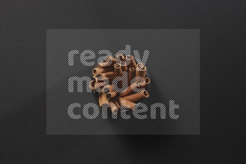 Cinnamon sticks in a black bowl on a black background in different angles