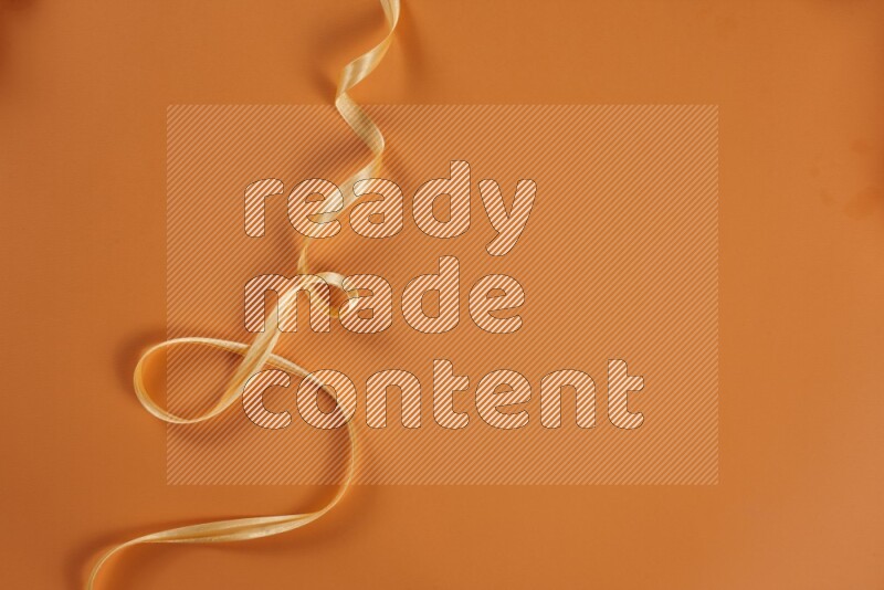 A yellow collection of sewing and tailoring tools arranged on a orange background