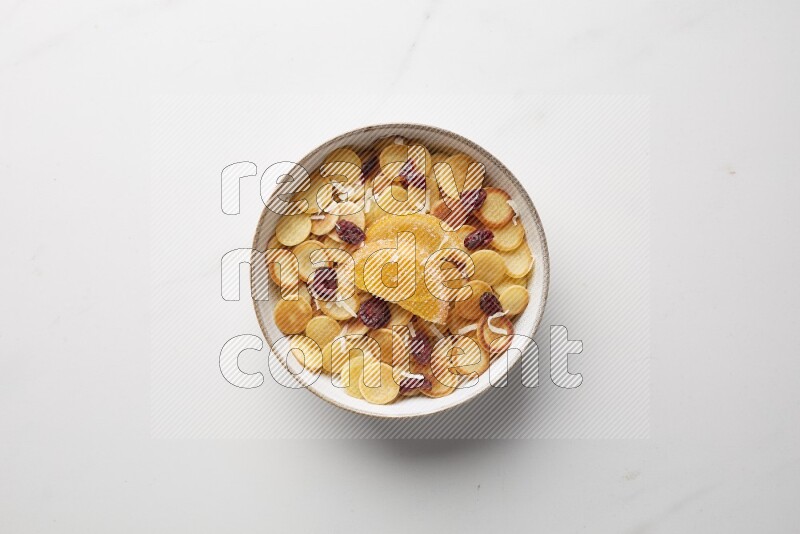 Top-view shot of orange candy cereal pancakes in a round bowl on white background