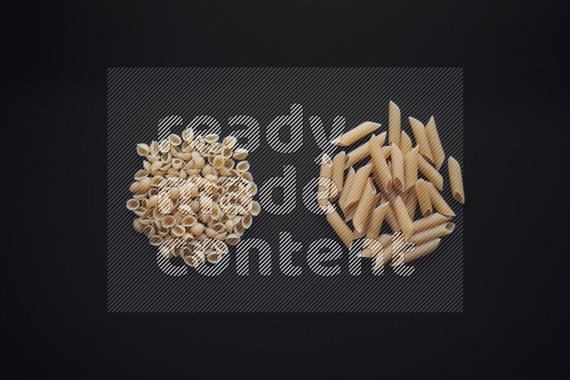 Different pasta types in bunches on black background
