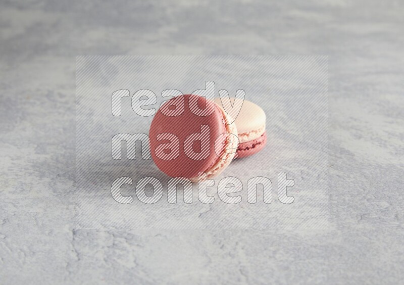 45º Shot of two Pink Litchi Raspberry macarons  on white  marble background
