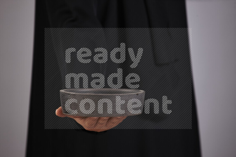 A woman in black abaya holding different pottery essentials in different positions