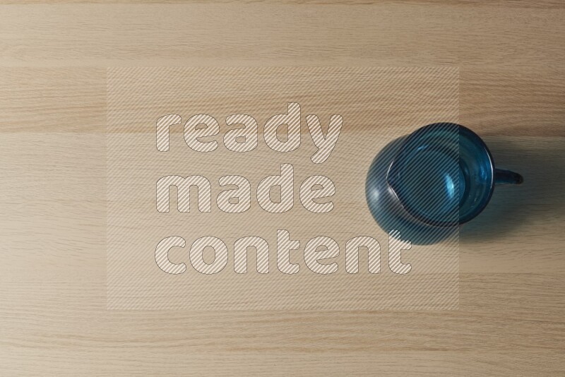 A colored glass jug on light wooden background