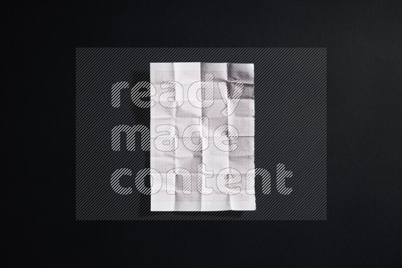 Folded notebook sheet on black background