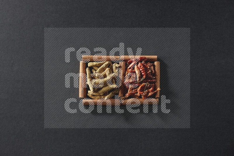 2 squares of cinnamon sticks full of chilis and turmeric fingers on black flooring