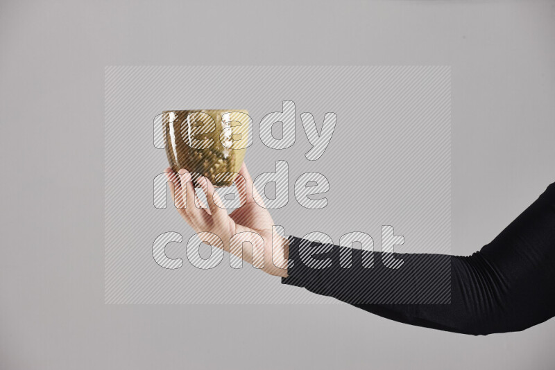A woman in black abaya holding different pottery essentials in different positions