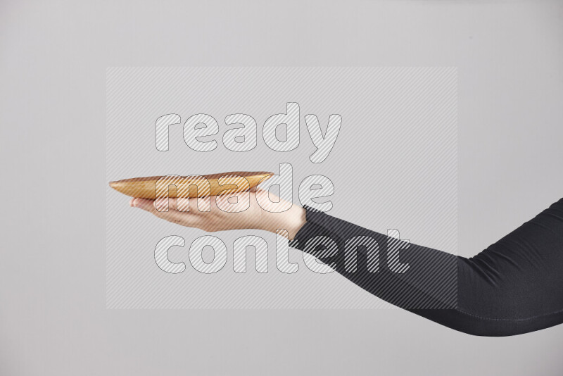A woman in black abaya holding different wooden essentials in different positions
