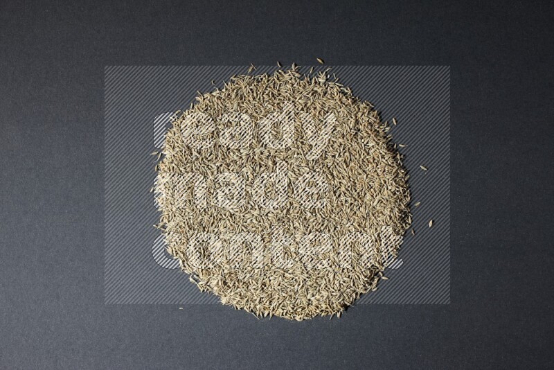 Cumin seeds on black flooring