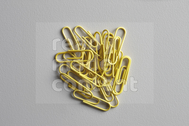 Yellow paper clips isolated on a grey background