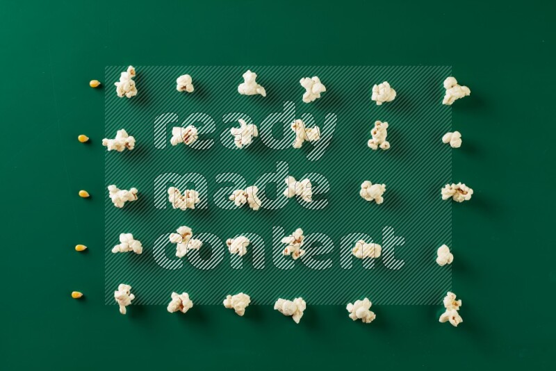 Popcorn flakes and seeds on a green background in a top view shot