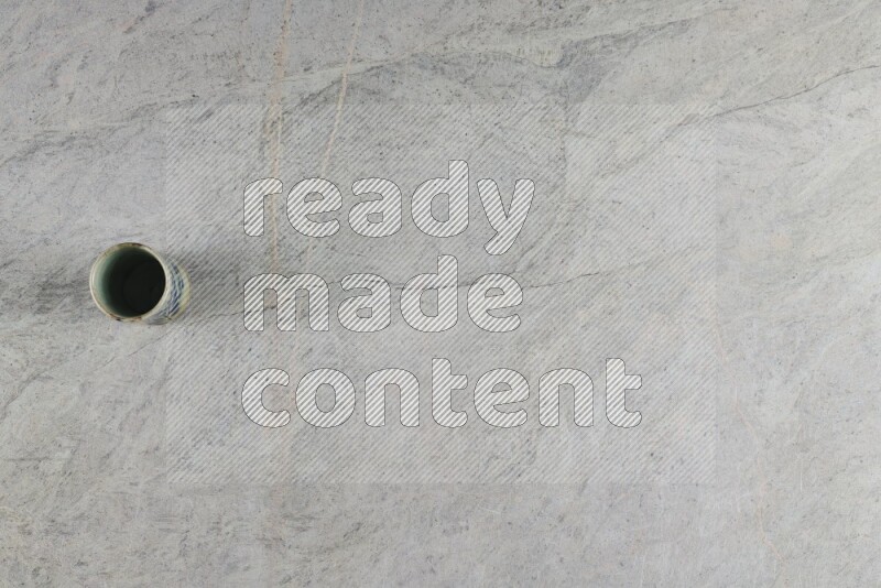 A multicolored pottery Cup on grey marble background