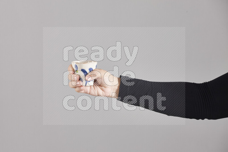 A woman in black abaya holding different pottery essentials in different positions