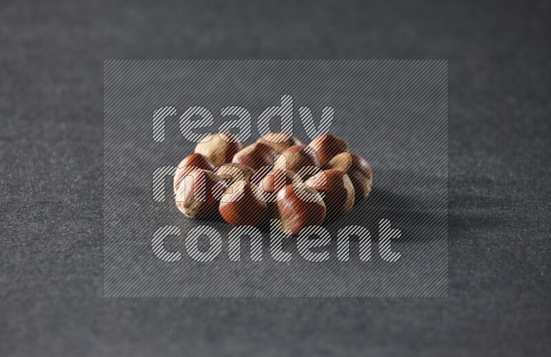 A bunch of hazelnuts on a black background in different angles