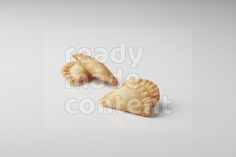 Four fried sambosas on a white background