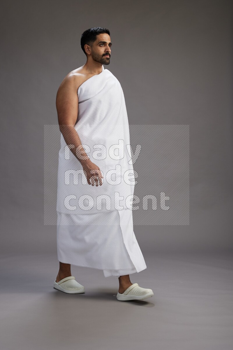 A man wearing Ehram Standing Interacting with the camera on gray background