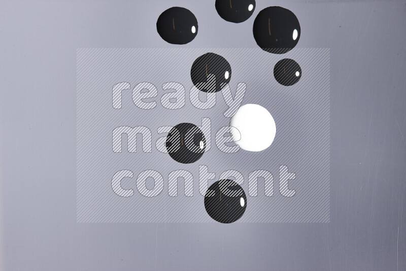 Close-ups of abstract white and black paint droplets on the surface