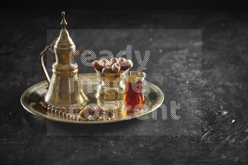 تمر مع مشروب ساخن على صينية معدنية