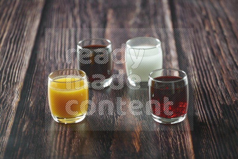 Cold drinks in a glass cup such as water, tamarind, qamar eldin, sobia, milk and hibiscus on wooden background