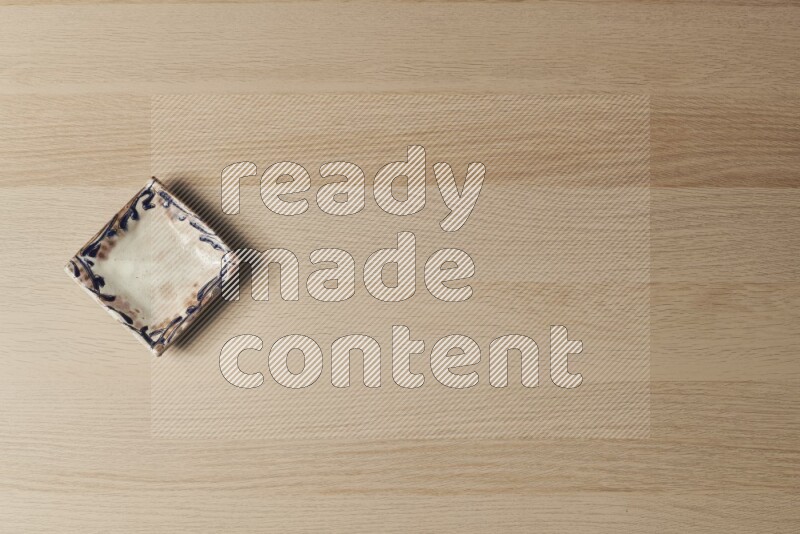 A decorative pottery plate on light wooden background